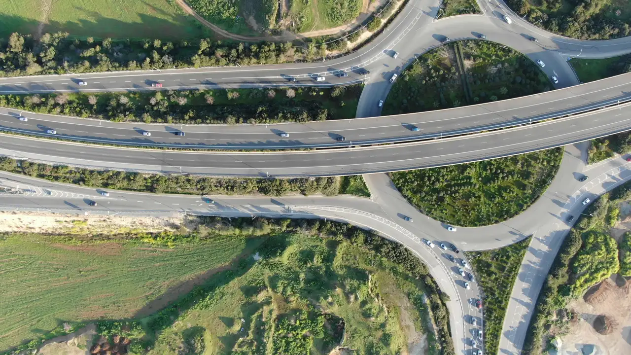 A drone photo of a road junction with queues of cars, with the 51 boxes SAM 3 returned for car, bus, truck.